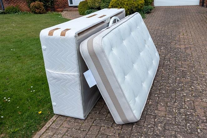 mattress being loaded onto a haul away truck